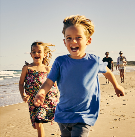 Happy children at the beach with carers.